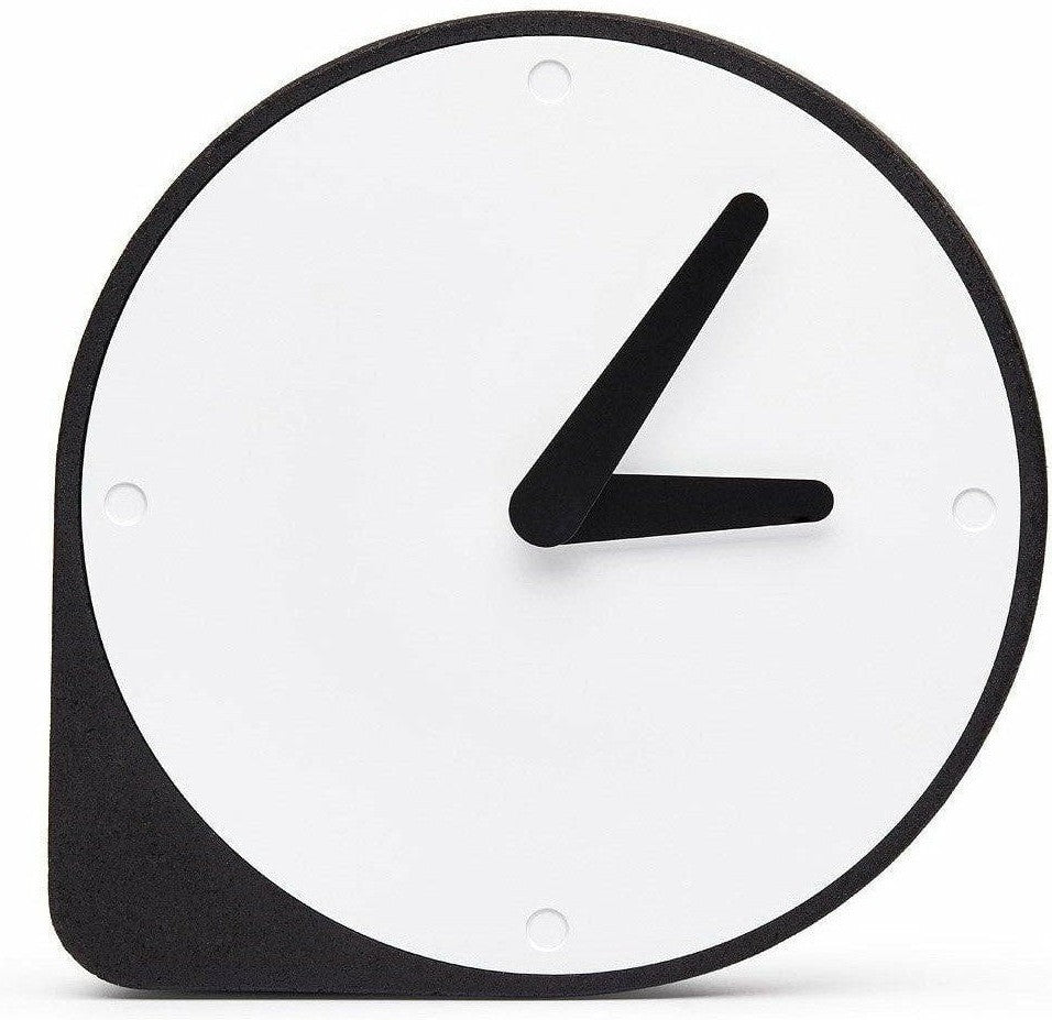 A Puik Clork table clock with an asymmetrical shape, sitting on a white surface.